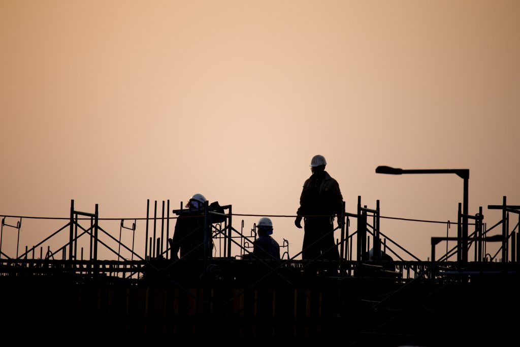 夕日の建築現場で働く人々